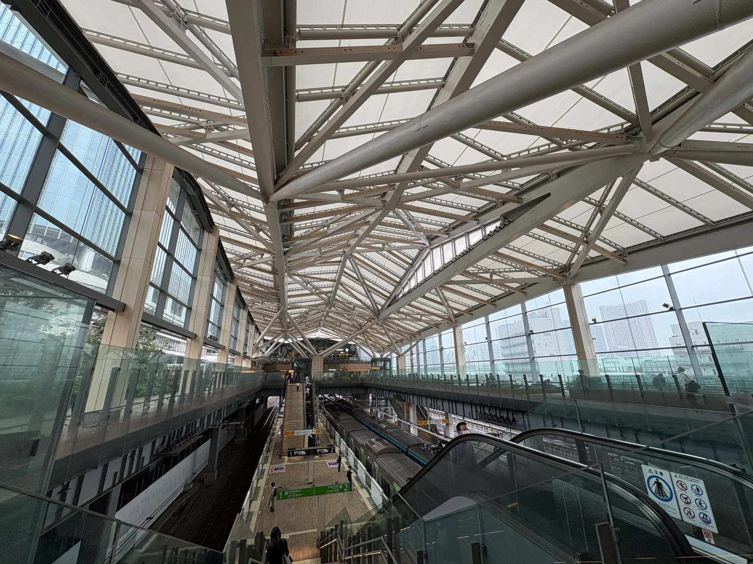The white lattice roof and platforms of Takanawa Gateway Station